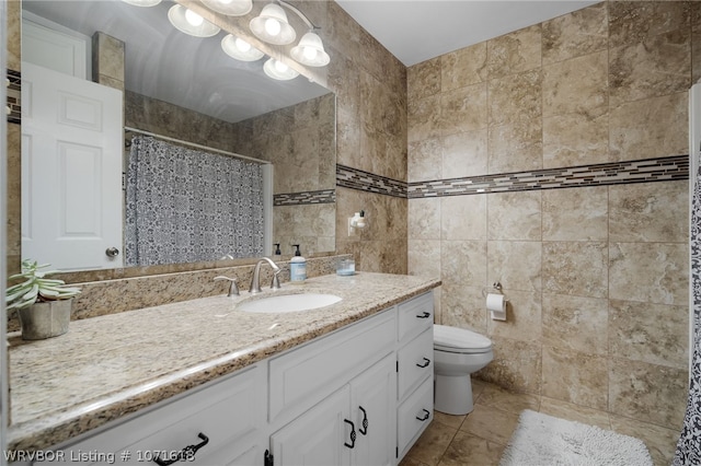 bathroom featuring vanity, tile patterned floors, a shower with shower curtain, toilet, and tile walls