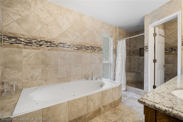 bathroom with vanity, separate shower and tub, and tile walls