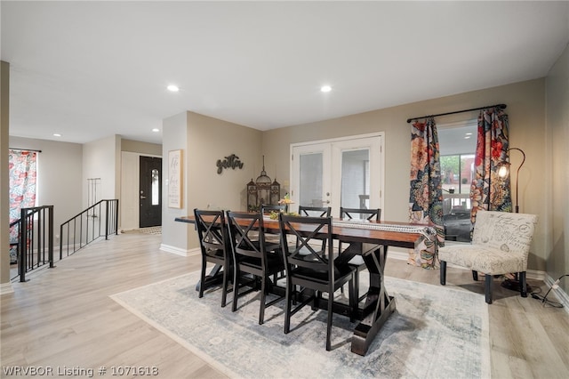 dining space with french doors and light hardwood / wood-style floors