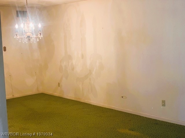 unfurnished room featuring a chandelier, carpet floors, and baseboards