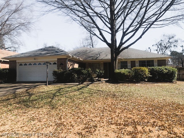 ranch-style house with a garage, concrete driveway, and brick siding