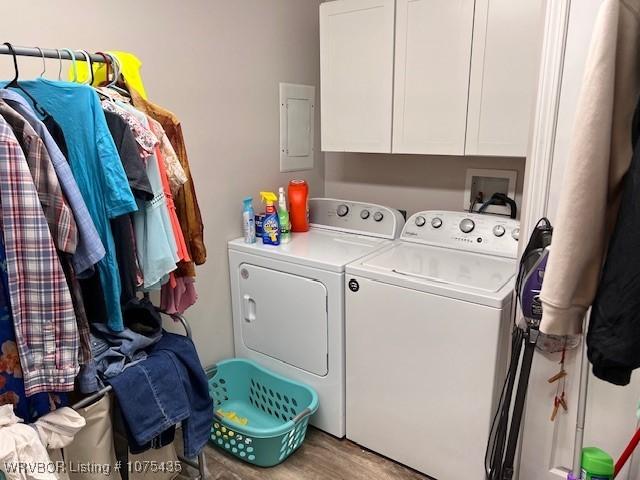 washroom featuring cabinets, light hardwood / wood-style flooring, and washing machine and clothes dryer