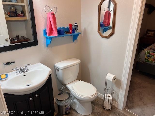 bathroom with hardwood / wood-style flooring, vanity, and toilet