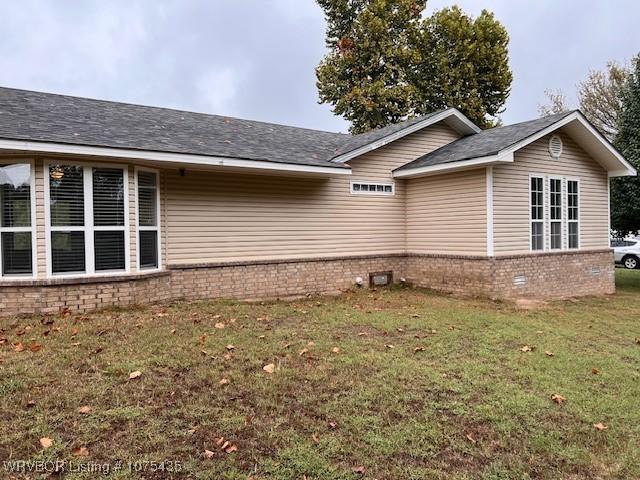 view of side of home with a lawn