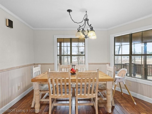 dining area featuring crown molding, dark hardwood / wood-style flooring, and a chandelier