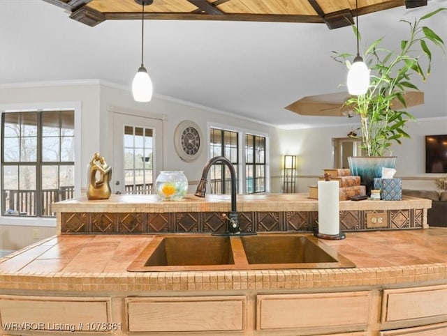 kitchen with light brown cabinetry, sink, wood ceiling, decorative light fixtures, and ornamental molding