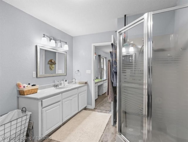 bathroom featuring vanity, wood-type flooring, and a shower with shower door