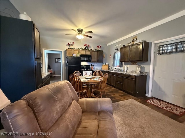 kitchen with sink, dark hardwood / wood-style floors, dark brown cabinetry, and black appliances