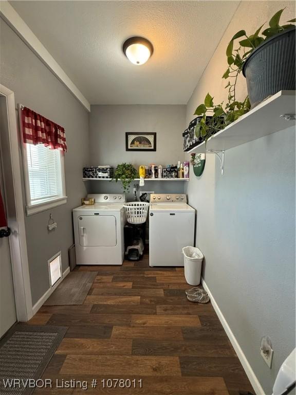 clothes washing area with dark hardwood / wood-style floors and washing machine and dryer