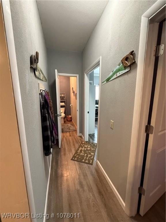 corridor with hardwood / wood-style flooring