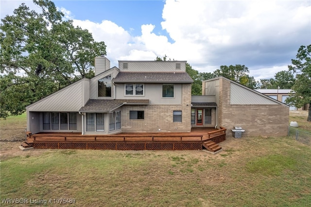 back of property with a lawn and a sunroom