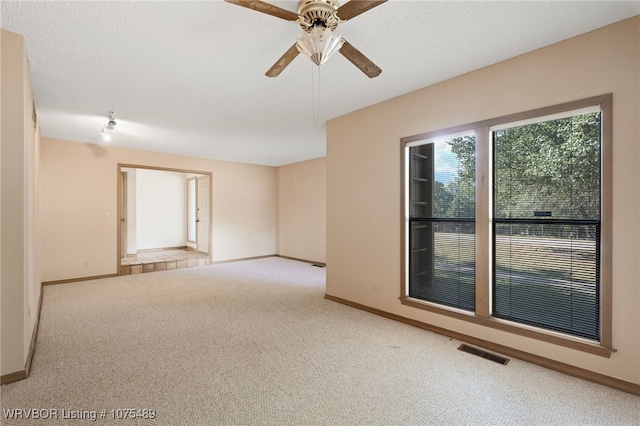 spare room featuring ceiling fan and light colored carpet