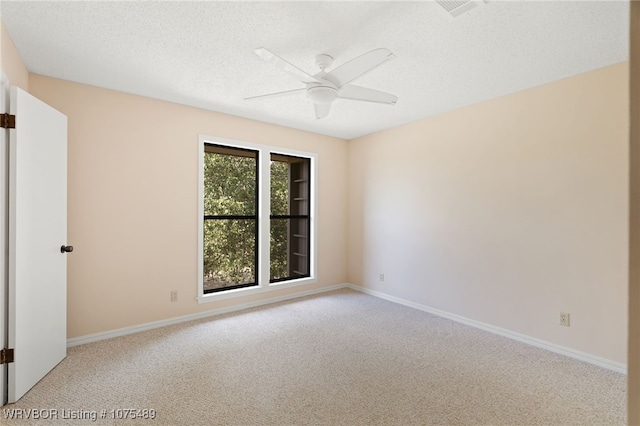 unfurnished room with a textured ceiling, ceiling fan, and light carpet