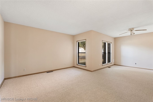 spare room with carpet flooring, a textured ceiling, and ceiling fan