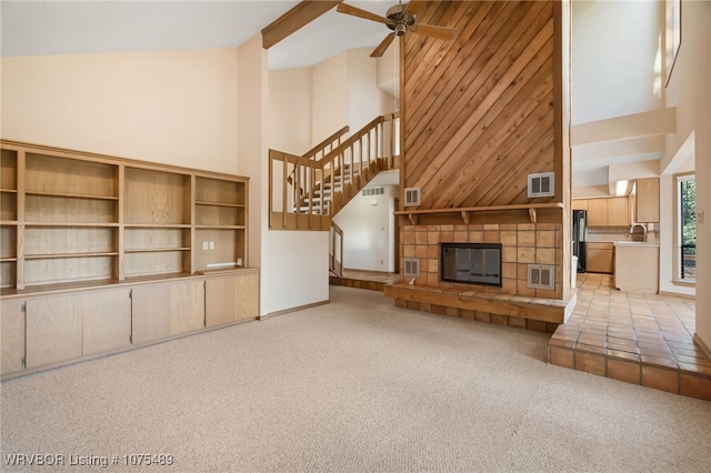 unfurnished living room with a fireplace, light colored carpet, and high vaulted ceiling