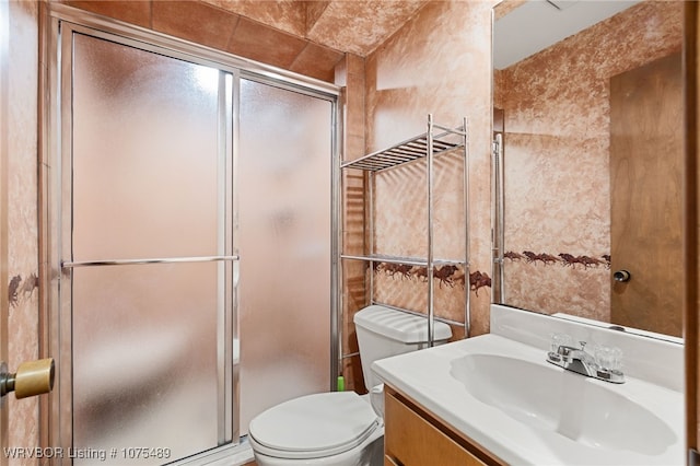 bathroom with vanity, toilet, and a shower with shower door