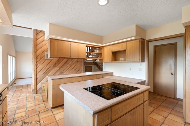 kitchen with black electric stovetop, a textured ceiling, and a kitchen island