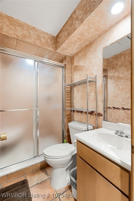 bathroom with tile patterned flooring, vanity, an enclosed shower, and toilet