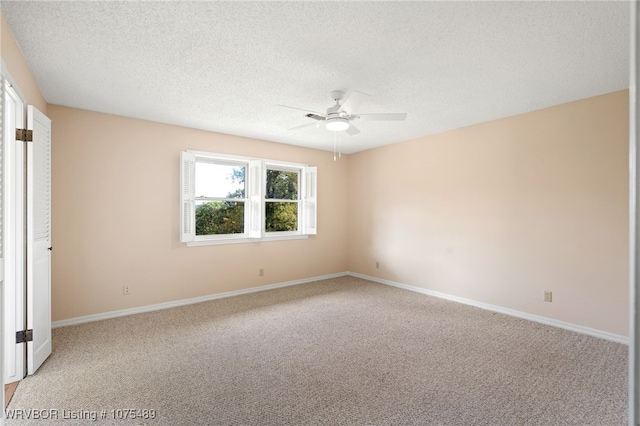 carpeted empty room featuring ceiling fan and a textured ceiling