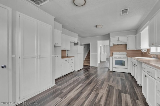 2101 N I St, Fort Smith, AR 72901 - kitchen with white appliances, a sink, under cabinet range hood, white cabinetry, and a textured ceiling