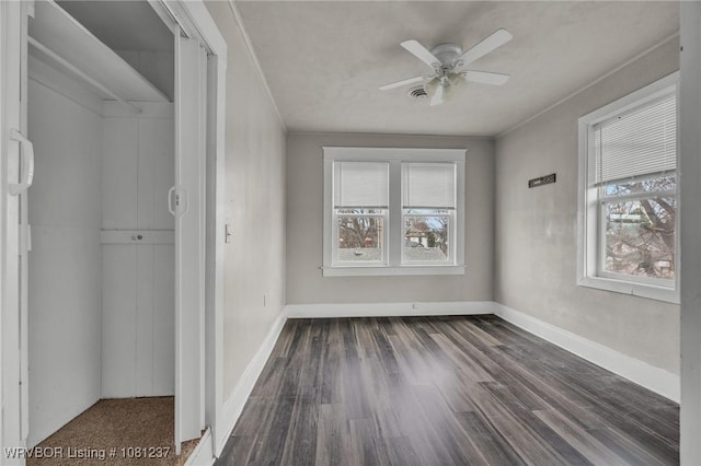 2101 N I St, Fort Smith, AR 72901 - unfurnished bedroom featuring dark wood-style floors, baseboards, a closet, and a ceiling fan