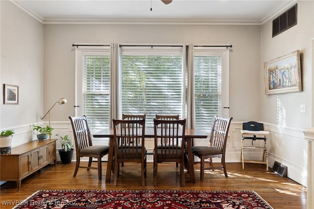 dining room with dark hardwood / wood-style flooring, crown molding, and a wealth of natural light