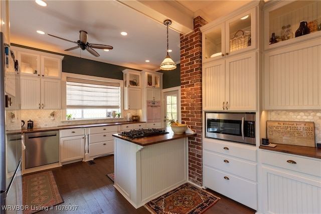 kitchen with butcher block counters, stainless steel appliances, dark hardwood / wood-style floors, decorative light fixtures, and white cabinets