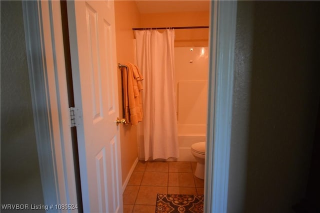 bathroom featuring shower / tub combo with curtain, tile patterned flooring, and toilet