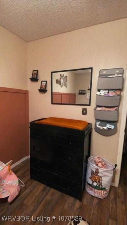 bedroom with dark wood-type flooring and a textured ceiling