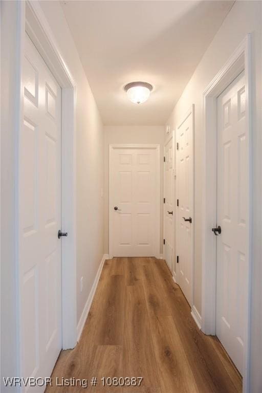 hallway with wood finished floors and baseboards