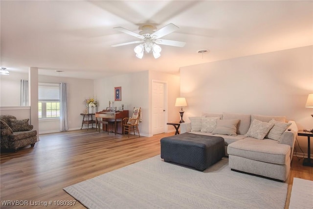 living room featuring wood finished floors, visible vents, a ceiling fan, and baseboards