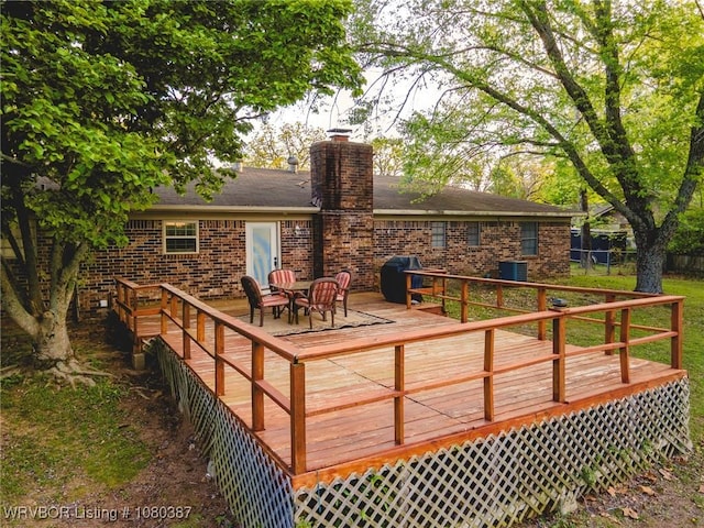wooden terrace featuring fence, grilling area, and central air condition unit