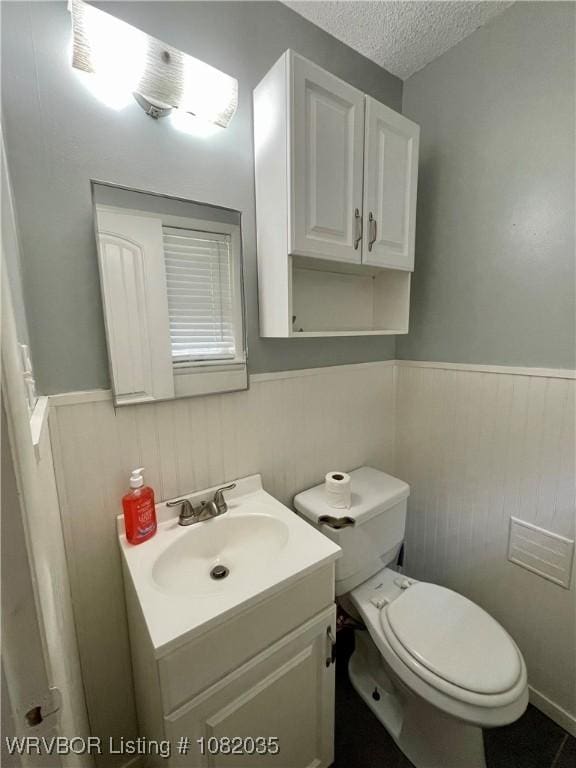 2119 55th Pl, Fort Smith, AR 72904 - half bath featuring wainscoting, vanity, a textured ceiling, and wood walls