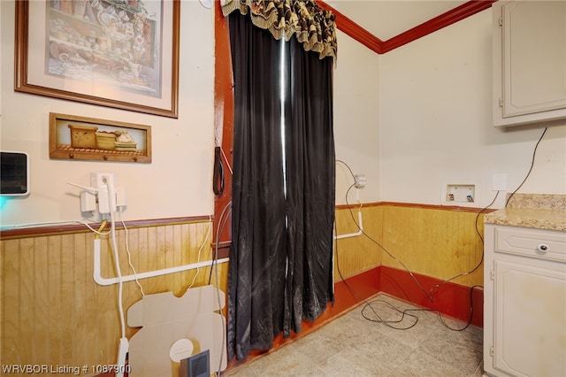 laundry room featuring wood walls, hookup for a washing machine, and ornamental molding