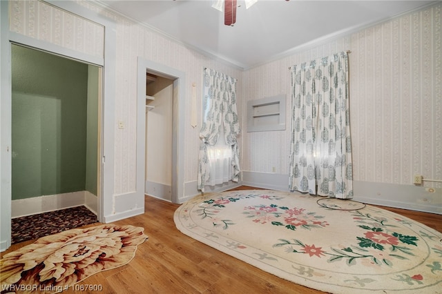 bedroom with crown molding, ceiling fan, and hardwood / wood-style flooring