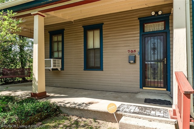 doorway to property featuring cooling unit and a porch