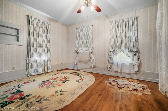 spare room featuring hardwood / wood-style flooring, ceiling fan, and ornamental molding