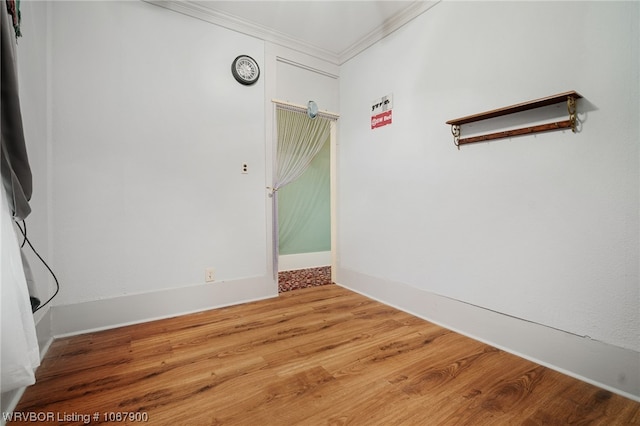 spare room featuring hardwood / wood-style floors and ornamental molding