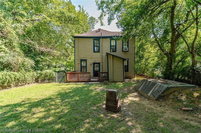 back of property with a yard and a wooden deck