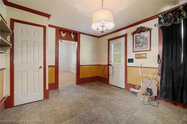 interior space featuring a notable chandelier, crown molding, and wood walls