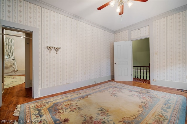 bedroom with ceiling fan, crown molding, and dark wood-type flooring