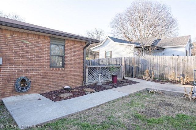 exterior space featuring fence and brick siding