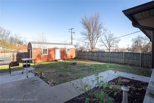 view of yard with an outbuilding, a patio area, an outdoor fire pit, and a fenced backyard