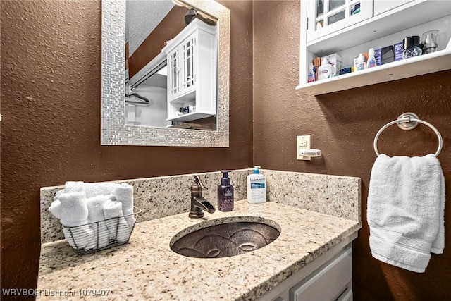 bathroom with vanity and a textured wall