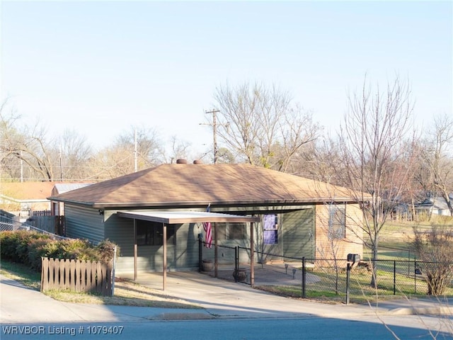 view of front facade featuring a carport, fence, and driveway