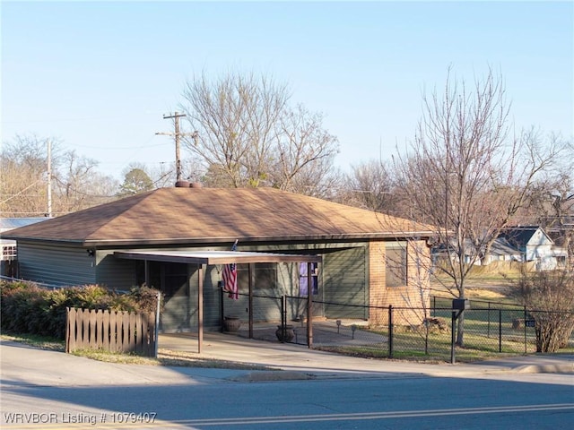 ranch-style house with an attached carport, driveway, and fence