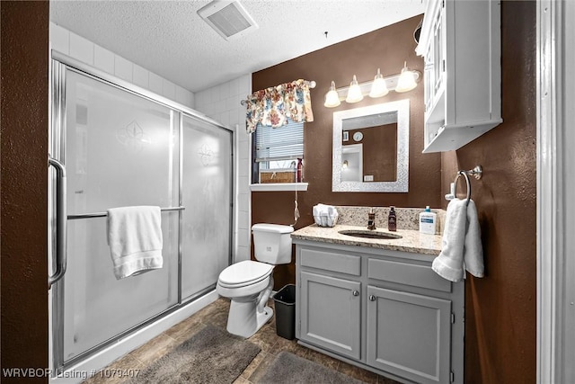 bathroom featuring visible vents, a textured ceiling, a stall shower, and toilet