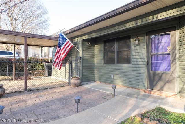 property entrance featuring a gate, covered porch, and fence