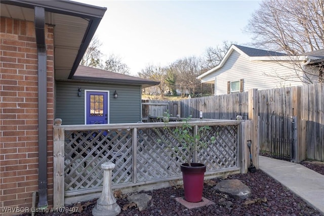 view of side of property featuring fence, brick siding, and a shingled roof