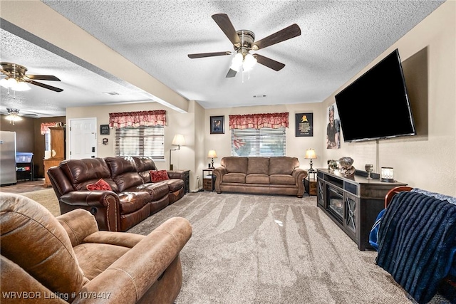 living area with a textured ceiling, a ceiling fan, and carpet floors